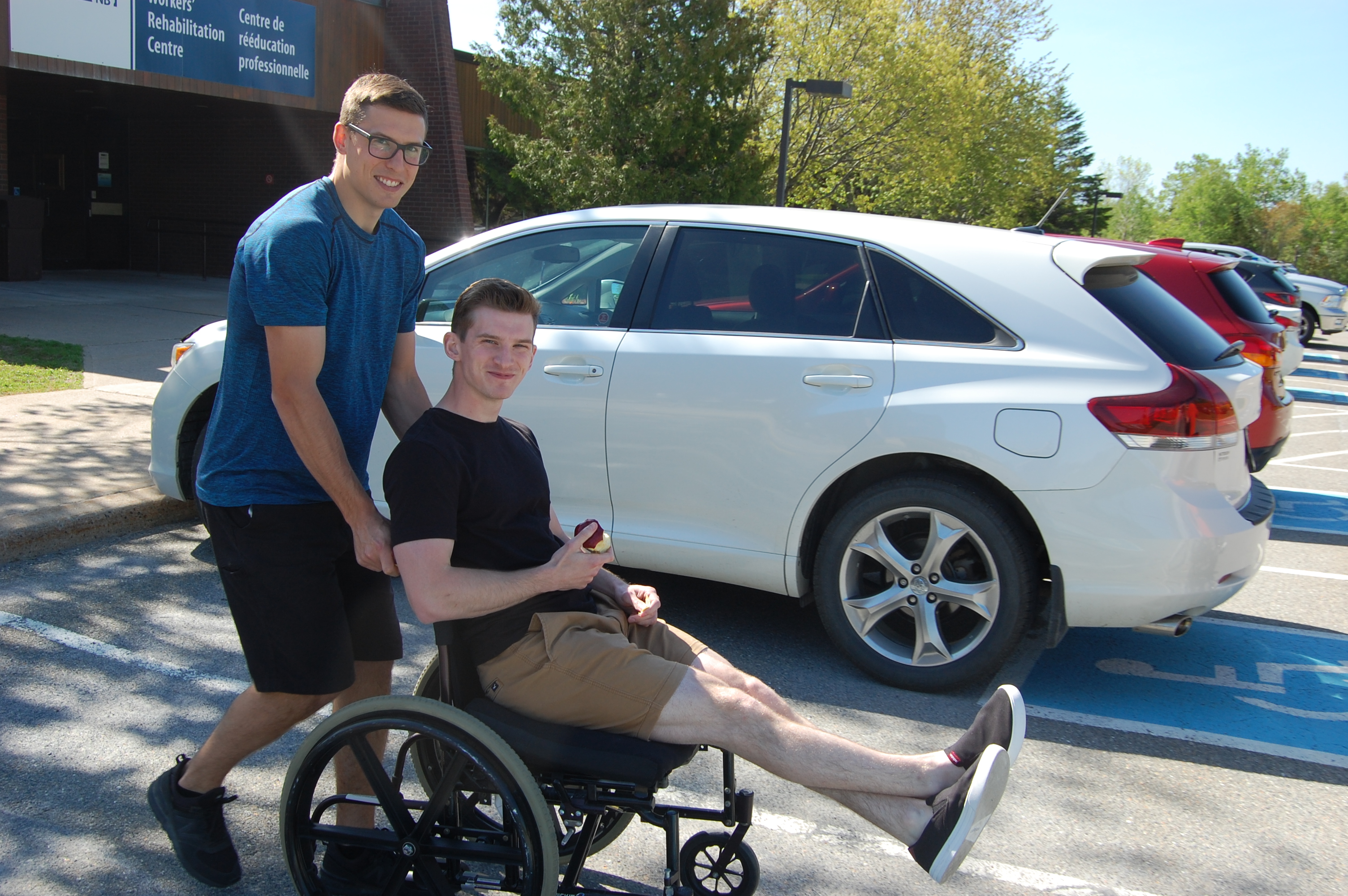 Un ergothérapeute de Travail sécuritaire NB, Andy West, aide Brandon Sloot, un stagiaire, à se déplacer en fauteuil roulant au Centre de rééducation de Travail sécuritaire NB à Grand Bay-Westfield.